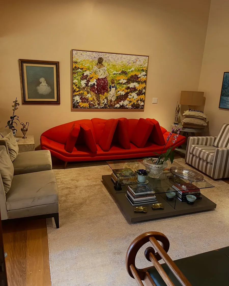 Sala de estar com sofá vermelho e tapete, um dos ambientes já atendidos pela Maria Lavadeira
